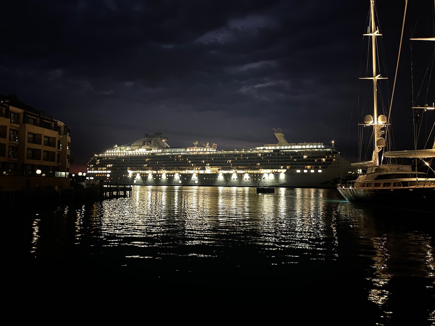 a cruise ship in a harbor at night