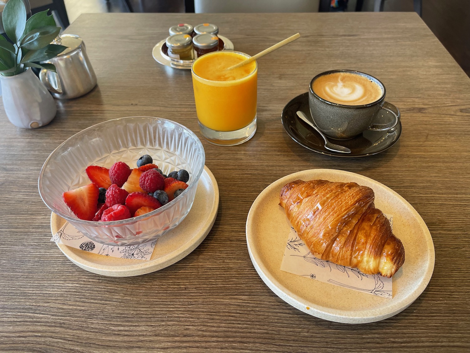 a plate of fruit and a croissant on a table