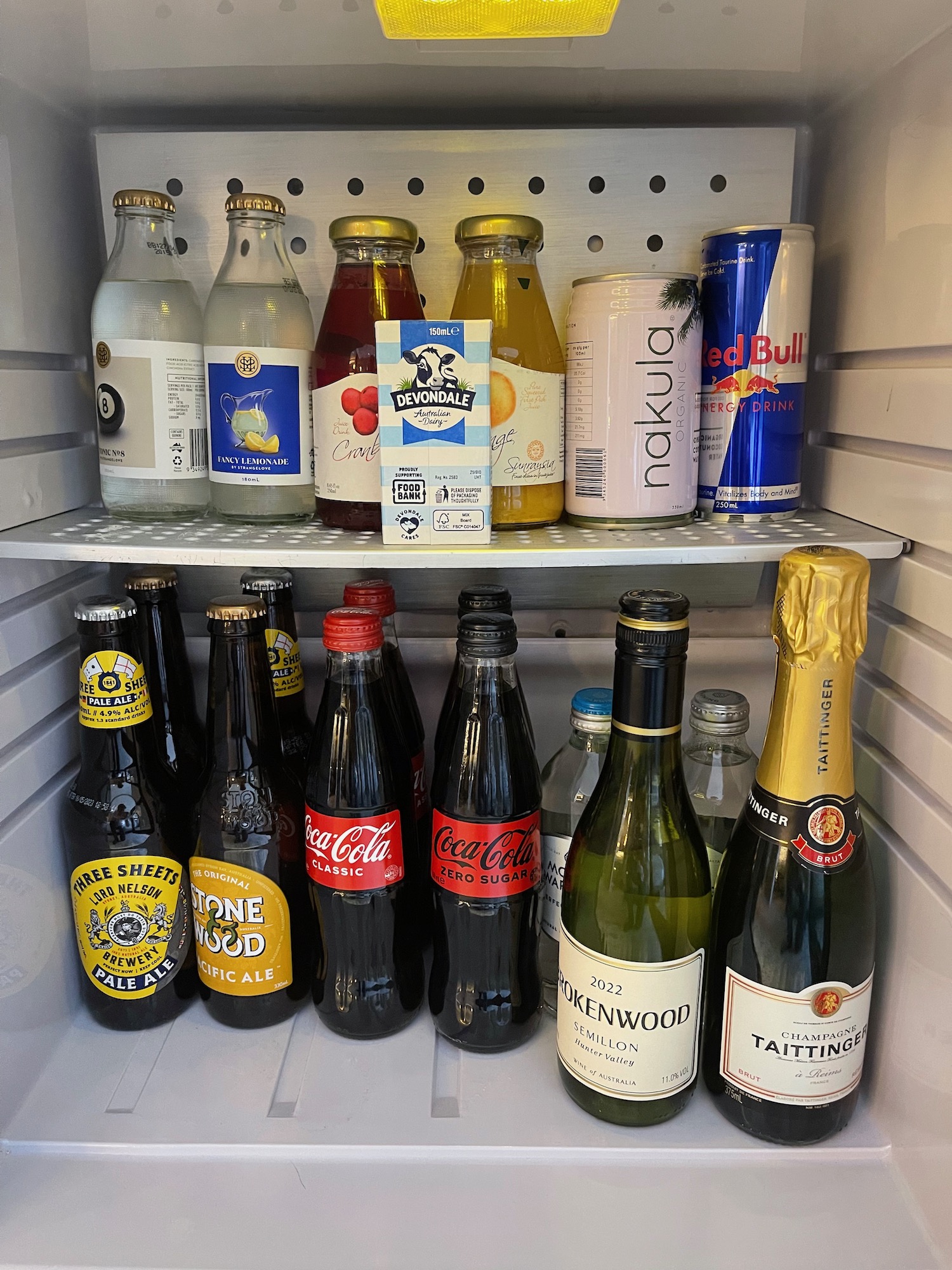 a refrigerator with bottles and cans of soda