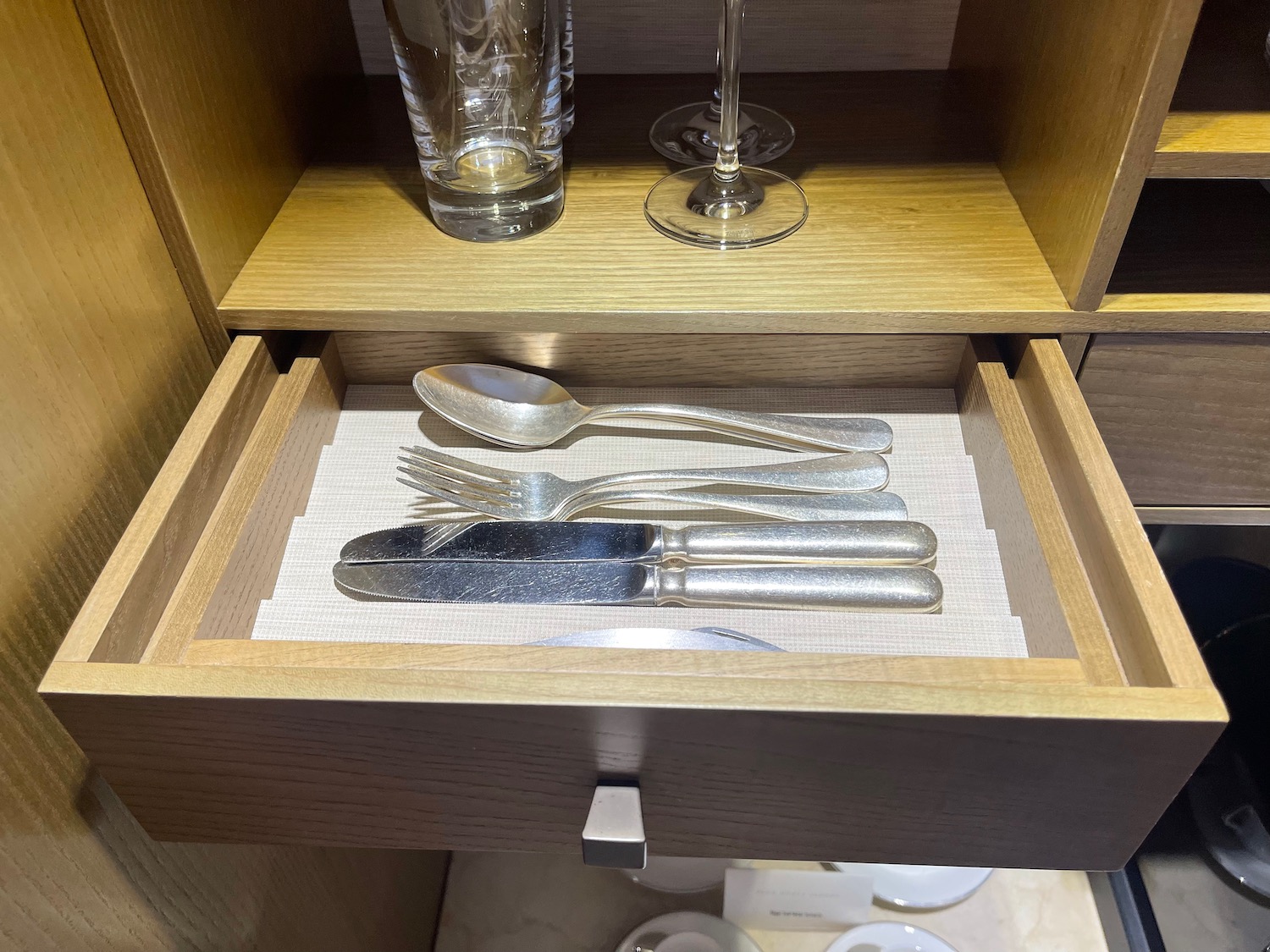 a drawer with silverware and glasses