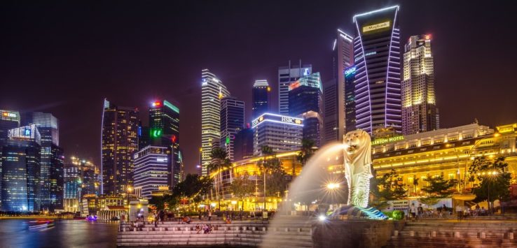 a lion statue with a fountain in front of a city skyline