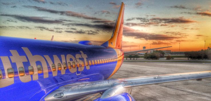 a blue and orange airplane on the runway