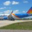 a blue and orange airplane on a runway