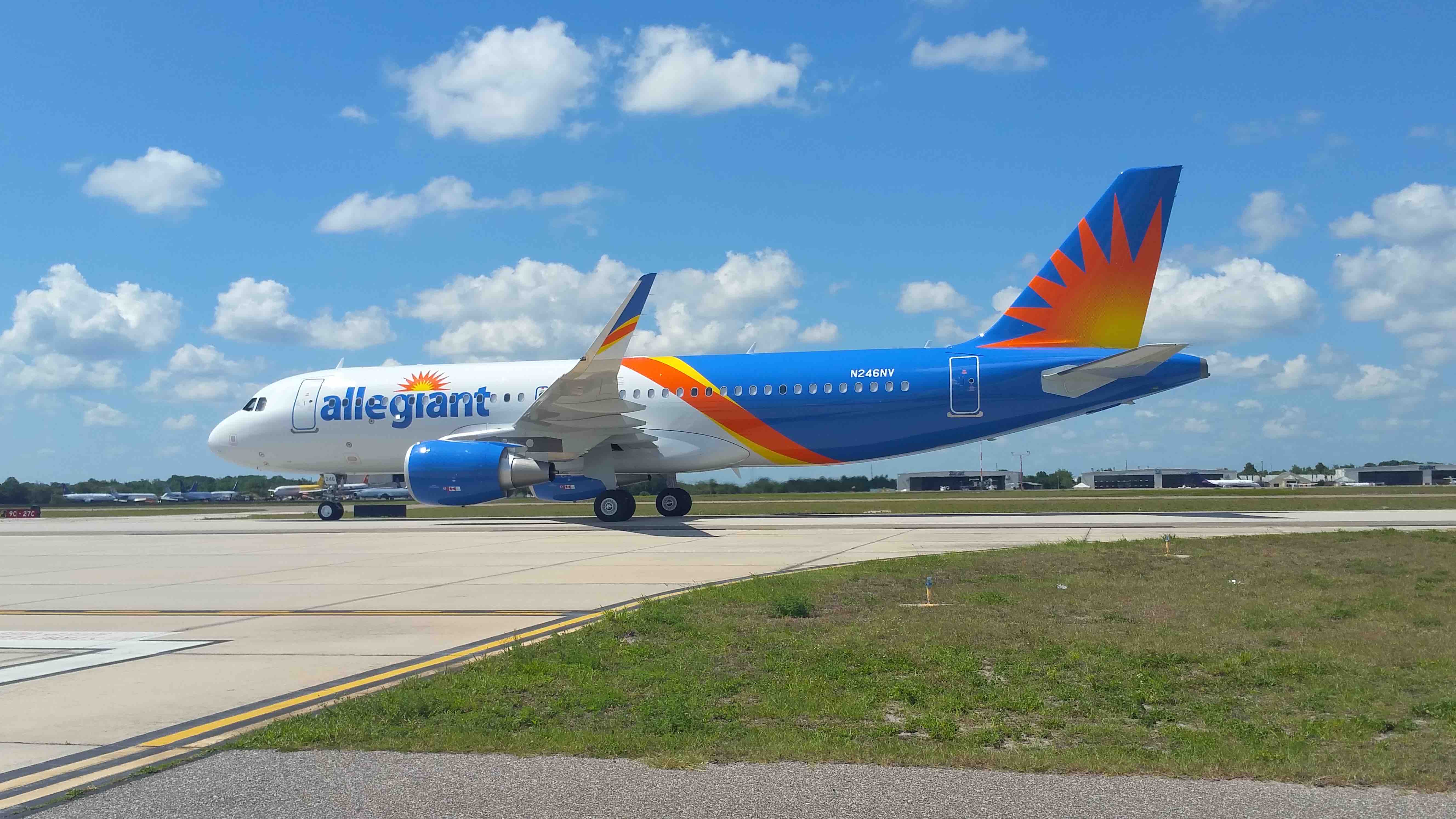 a blue and orange airplane on a runway