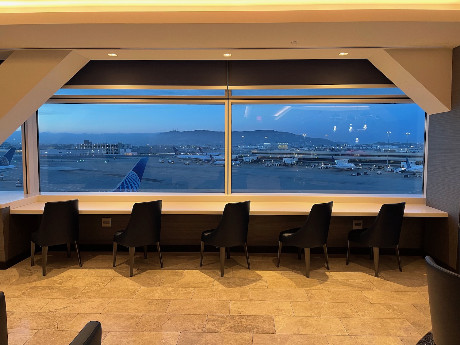 a row of chairs in a room with a large window