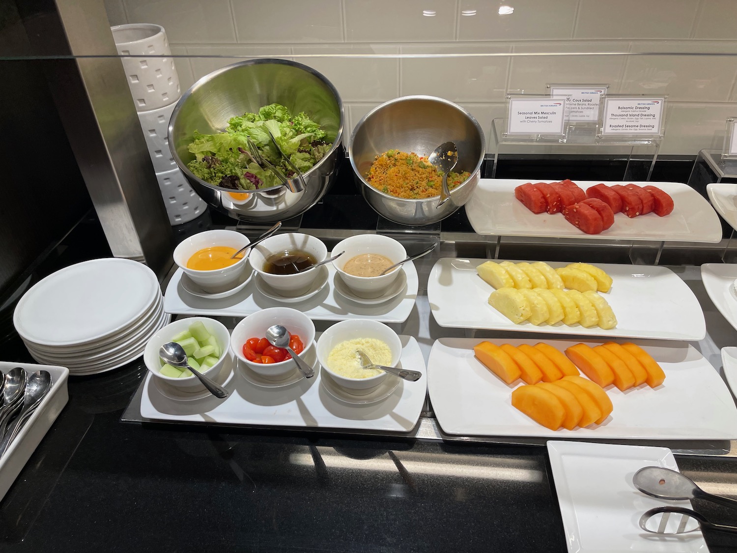 a buffet table with plates of food and bowls of food