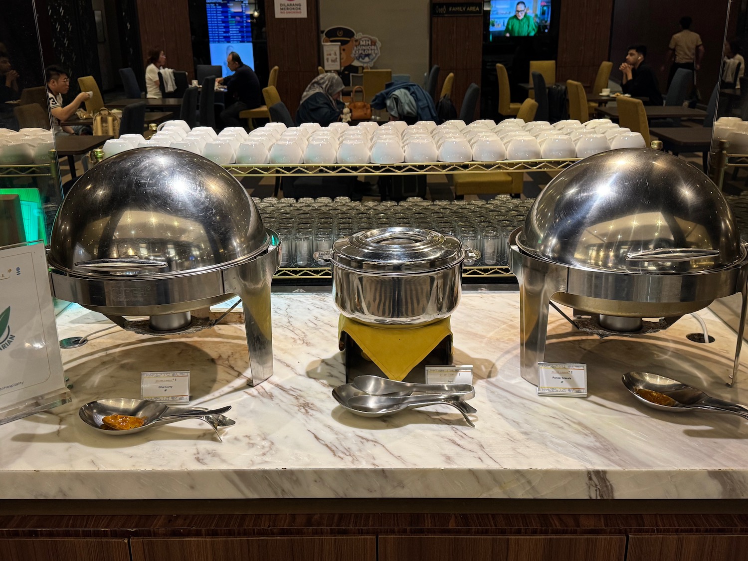 a buffet set up with a group of silver bowls and spoons