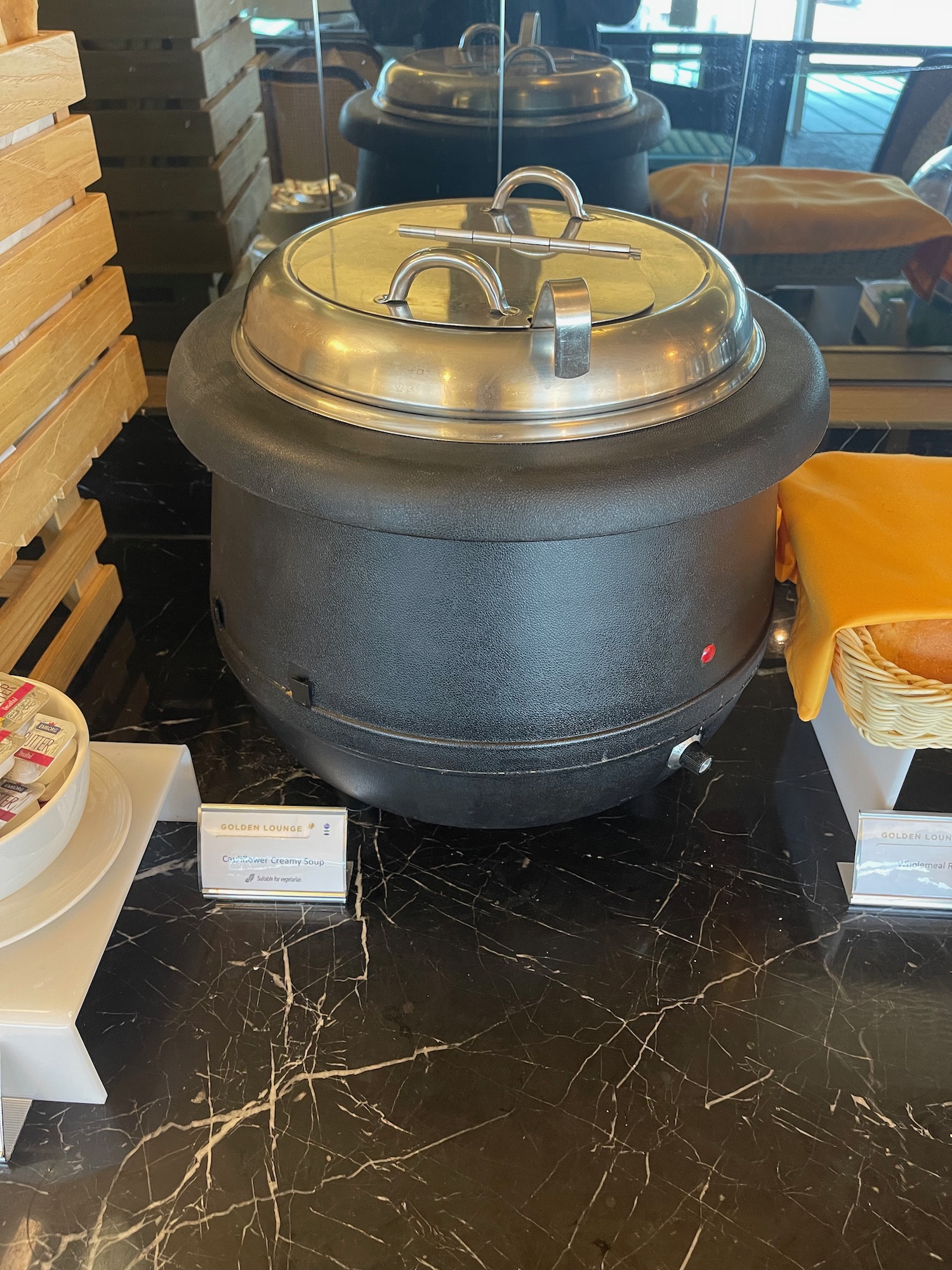 a large black pot with a silver lid on a marble surface