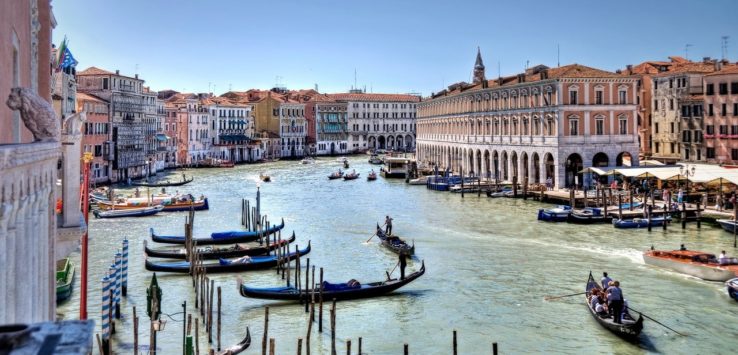 a group of boats in a canal with Grand Canal in the background