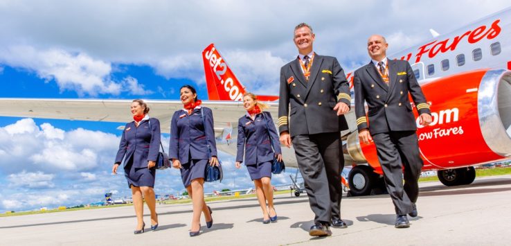 a group of people in uniform walking by an airplane