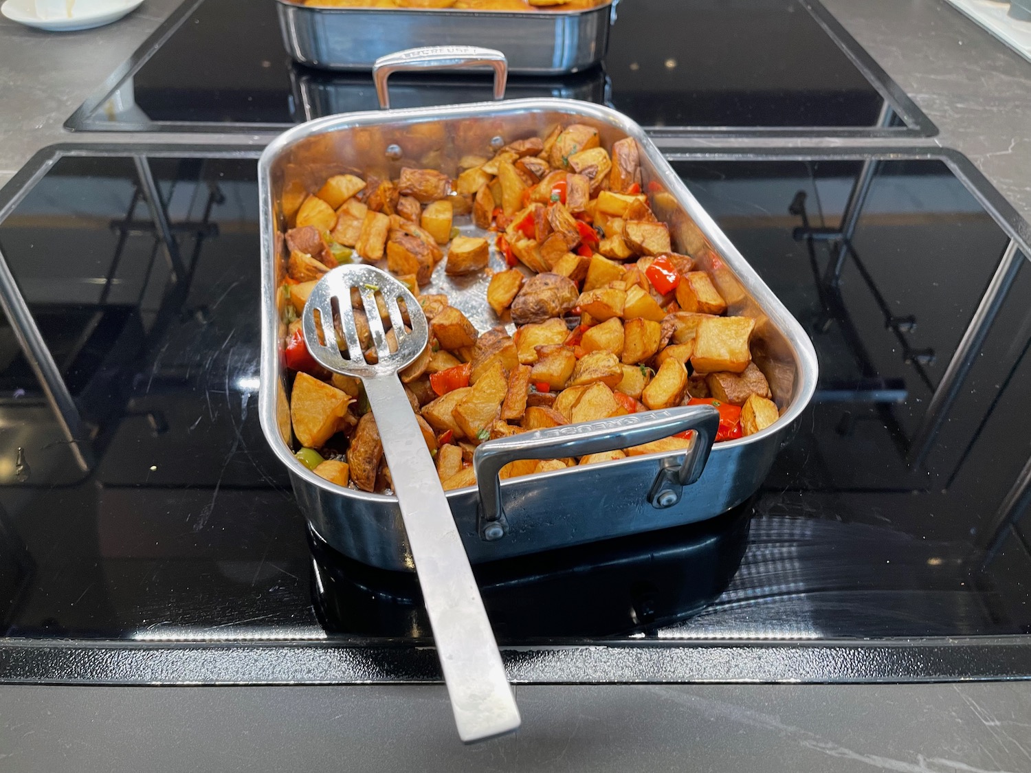 a pan of potatoes and peppers on a stove