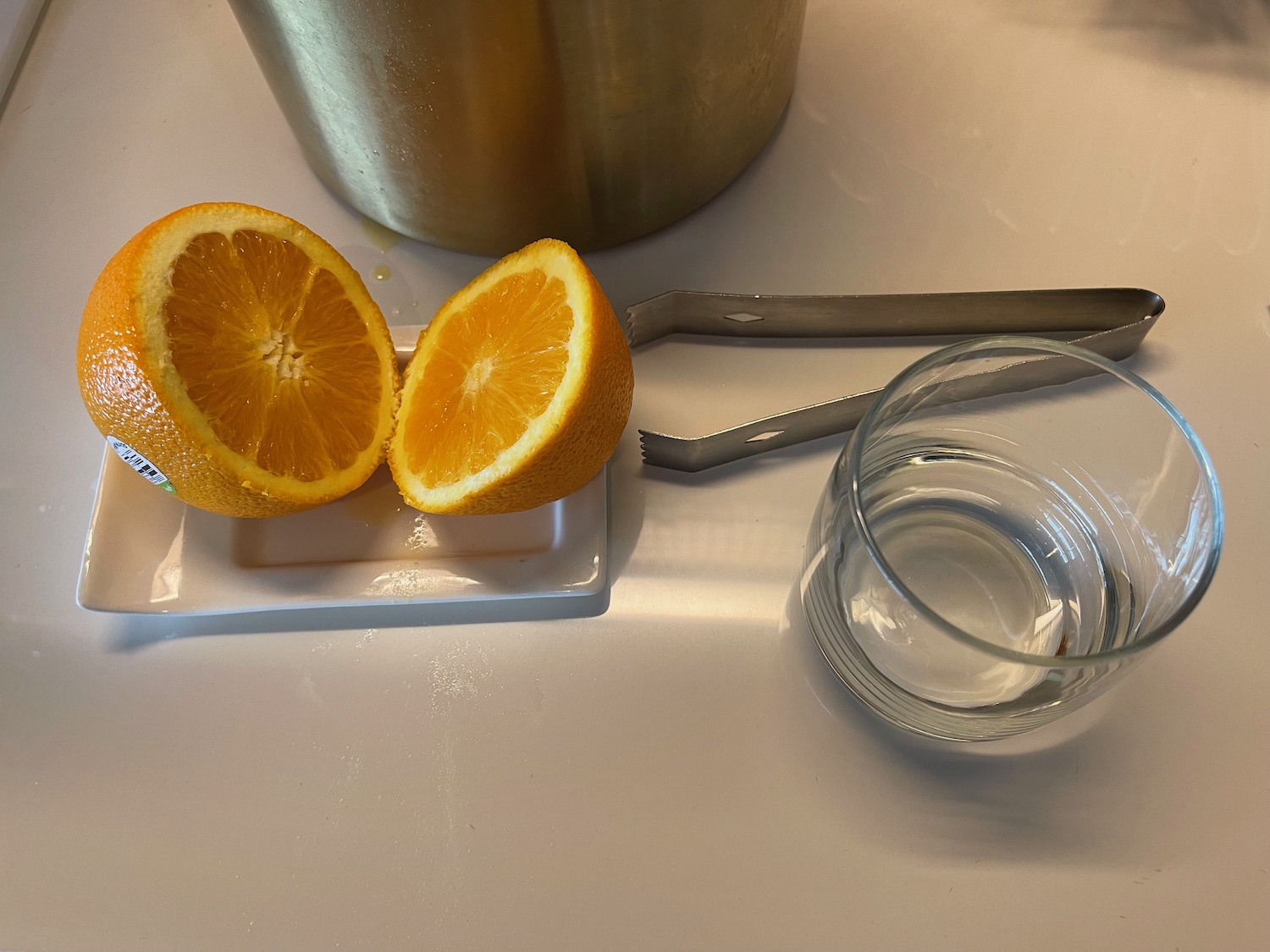 a sliced orange on a plate next to a glass of water