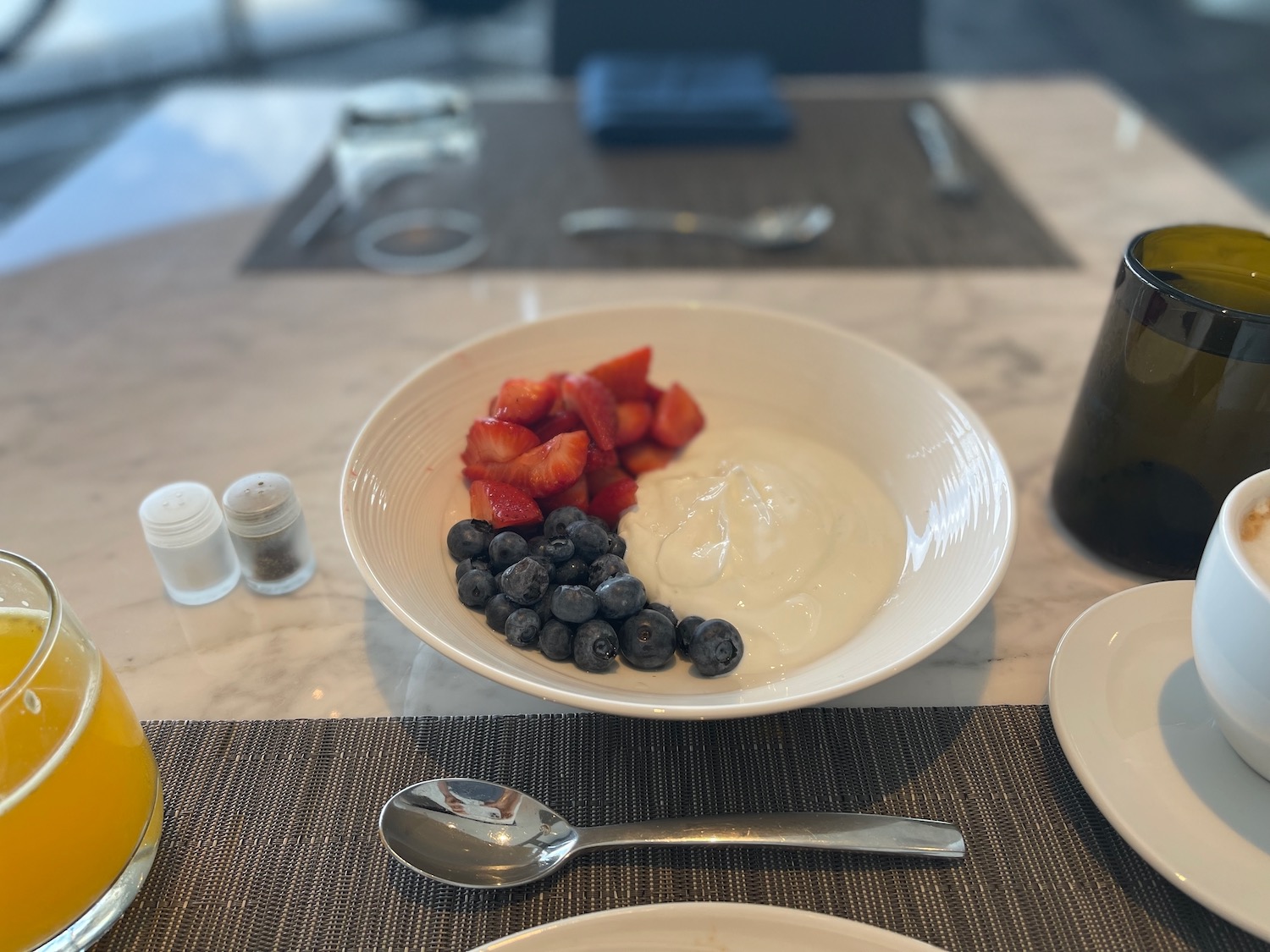 a bowl of fruit and cream on a table