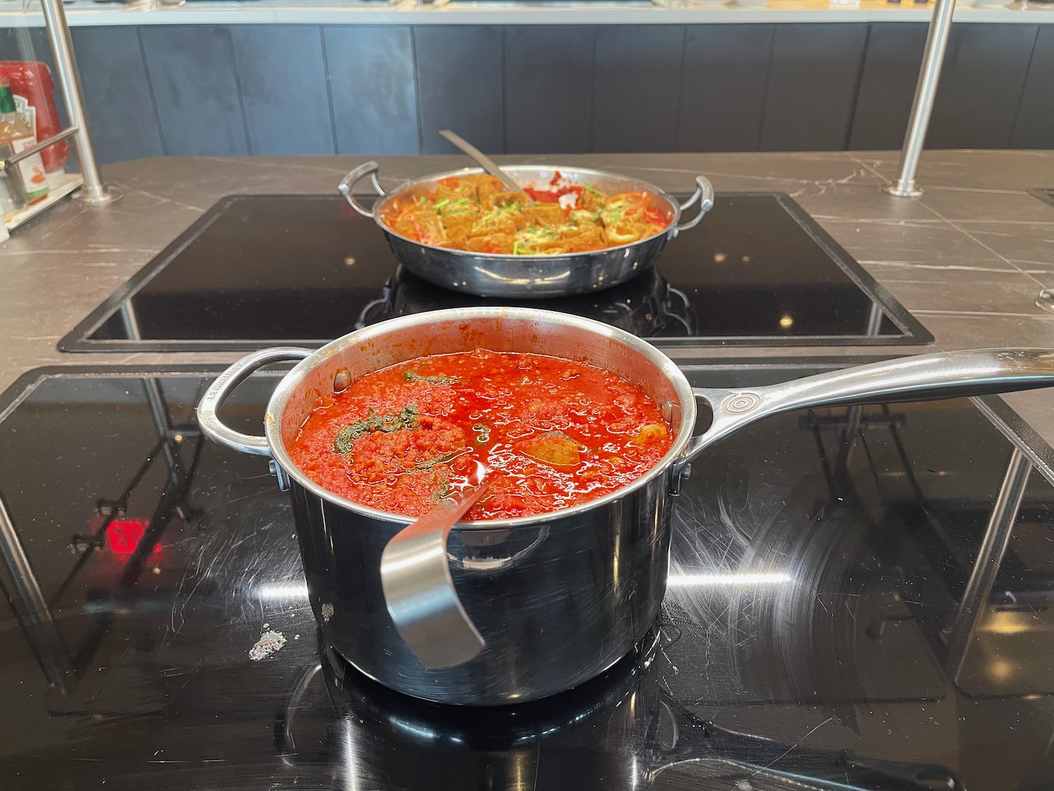 a couple of pots with soup on a stove