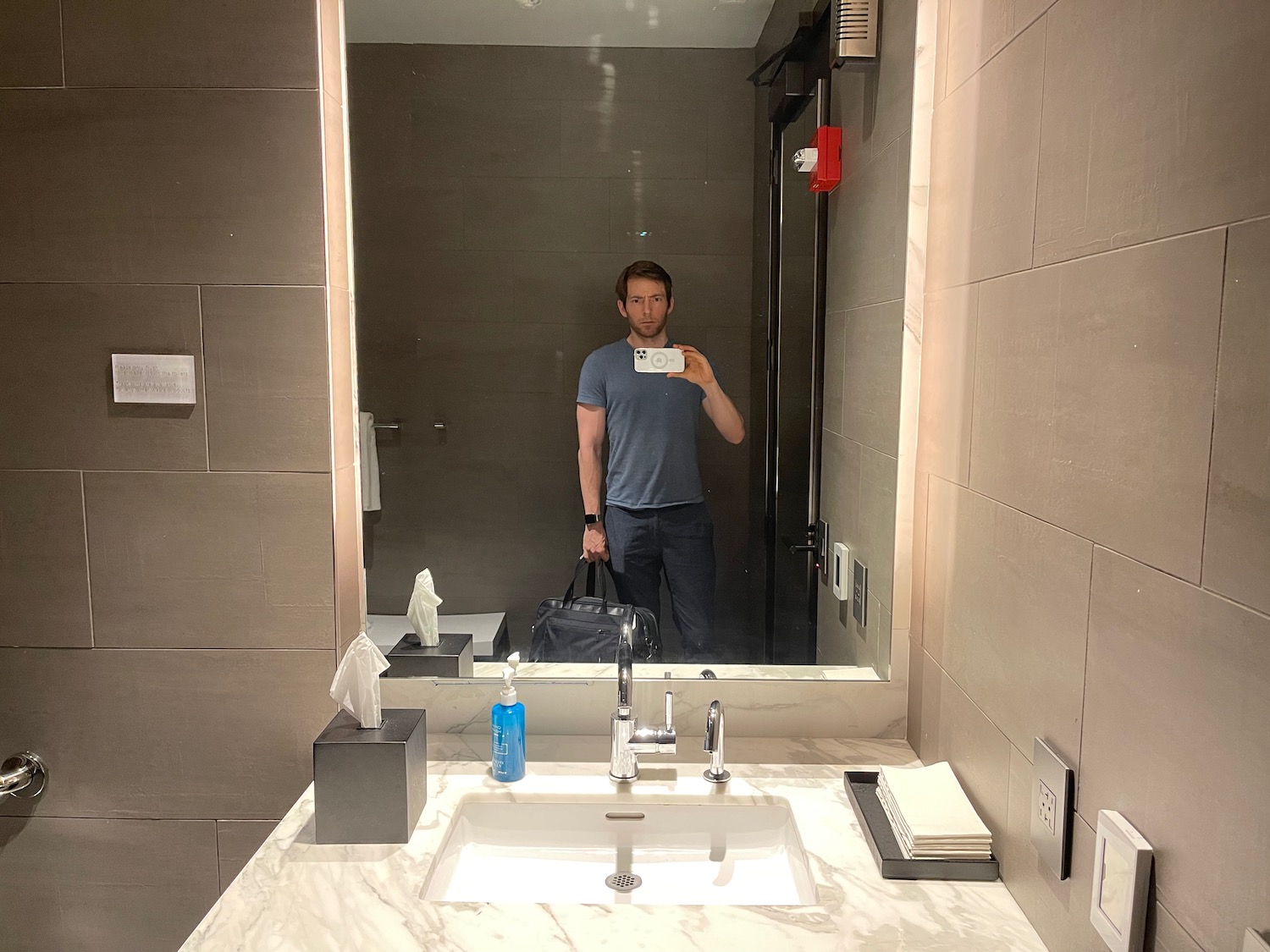 a man taking a selfie in a bathroom mirror