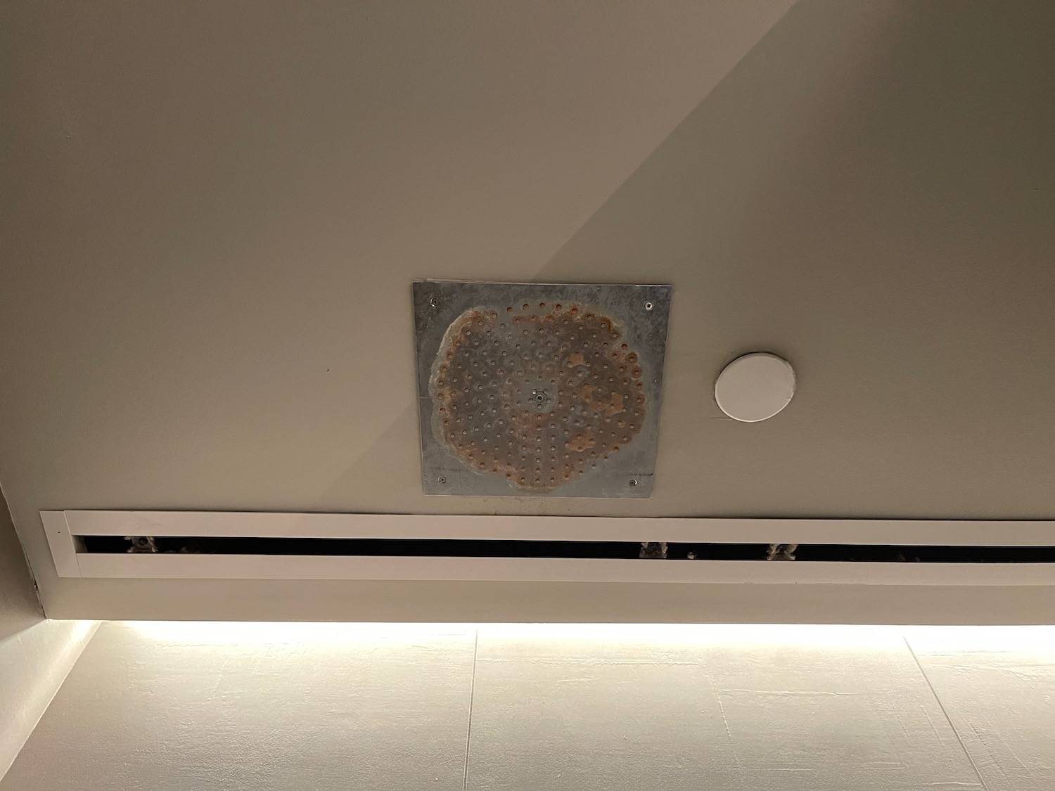 a metal square with holes on the ceiling