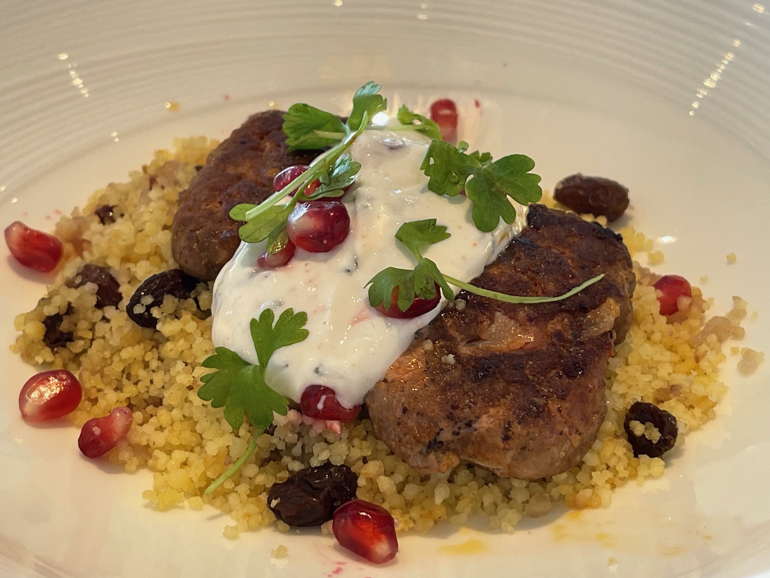 a plate of food with a white sauce and garnish