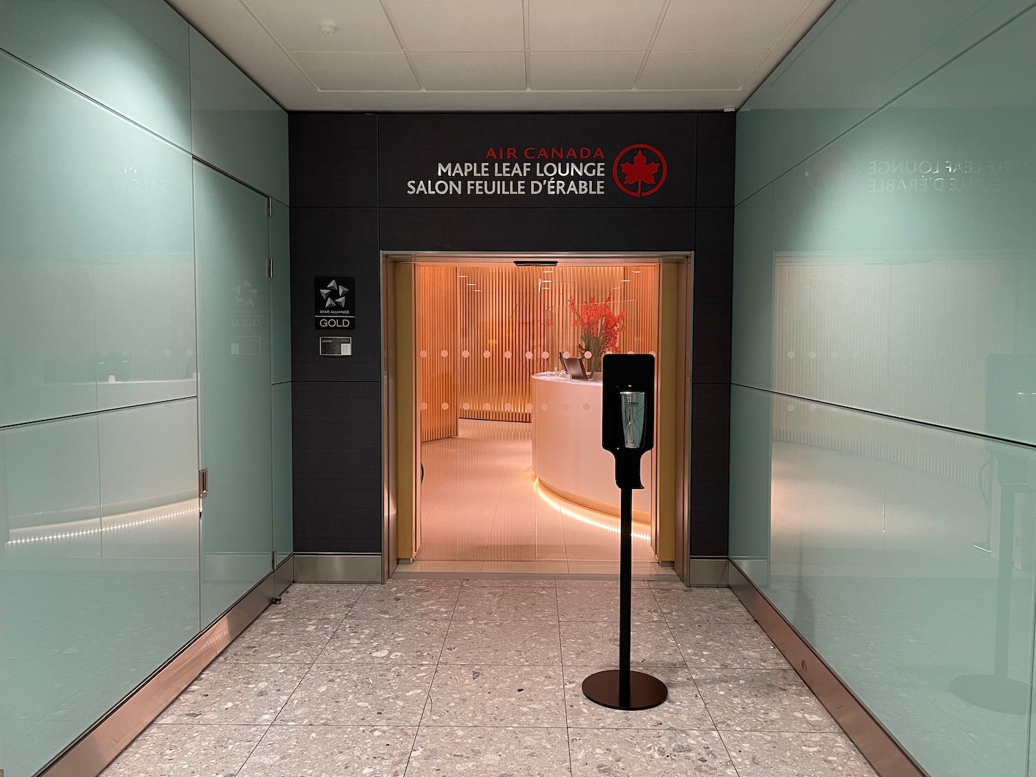 a hallway with a sign and a glass wall