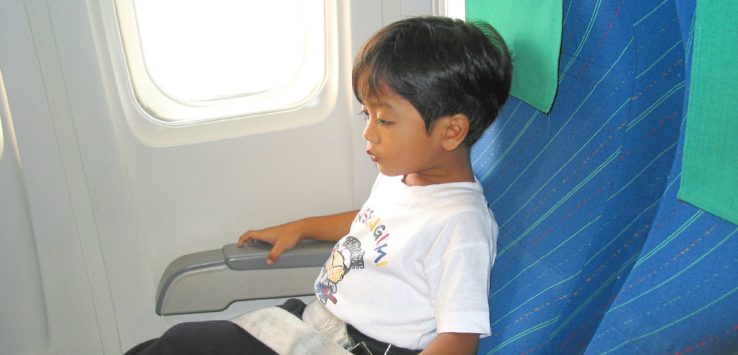 a child sitting in a seat on an airplane