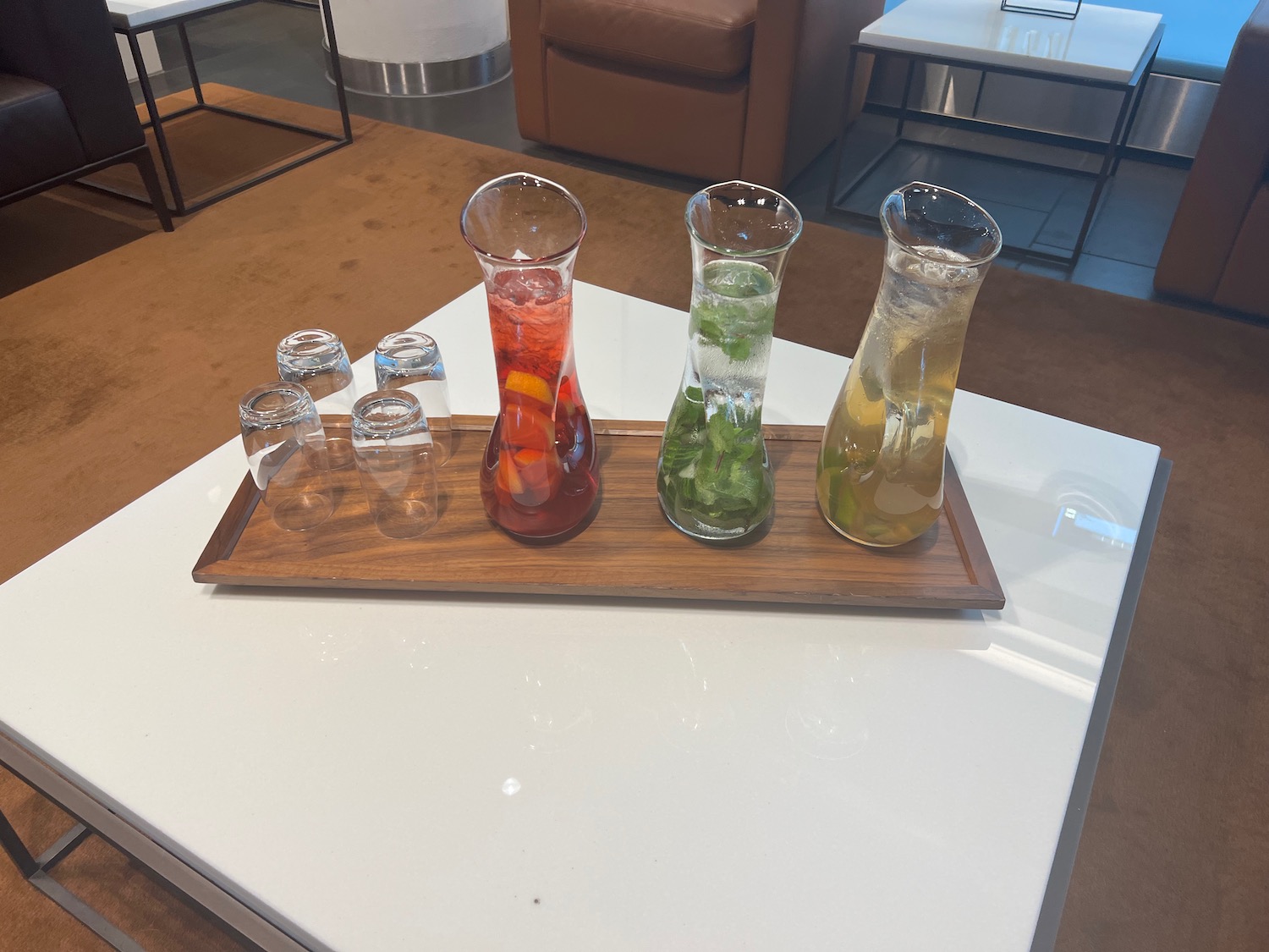 a group of glasses and bottles of liquid on a wood tray