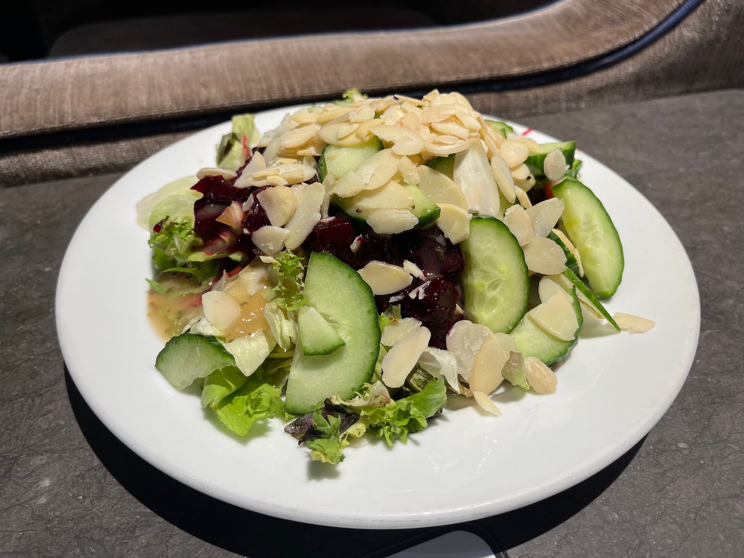 a plate of salad with cucumbers and almonds