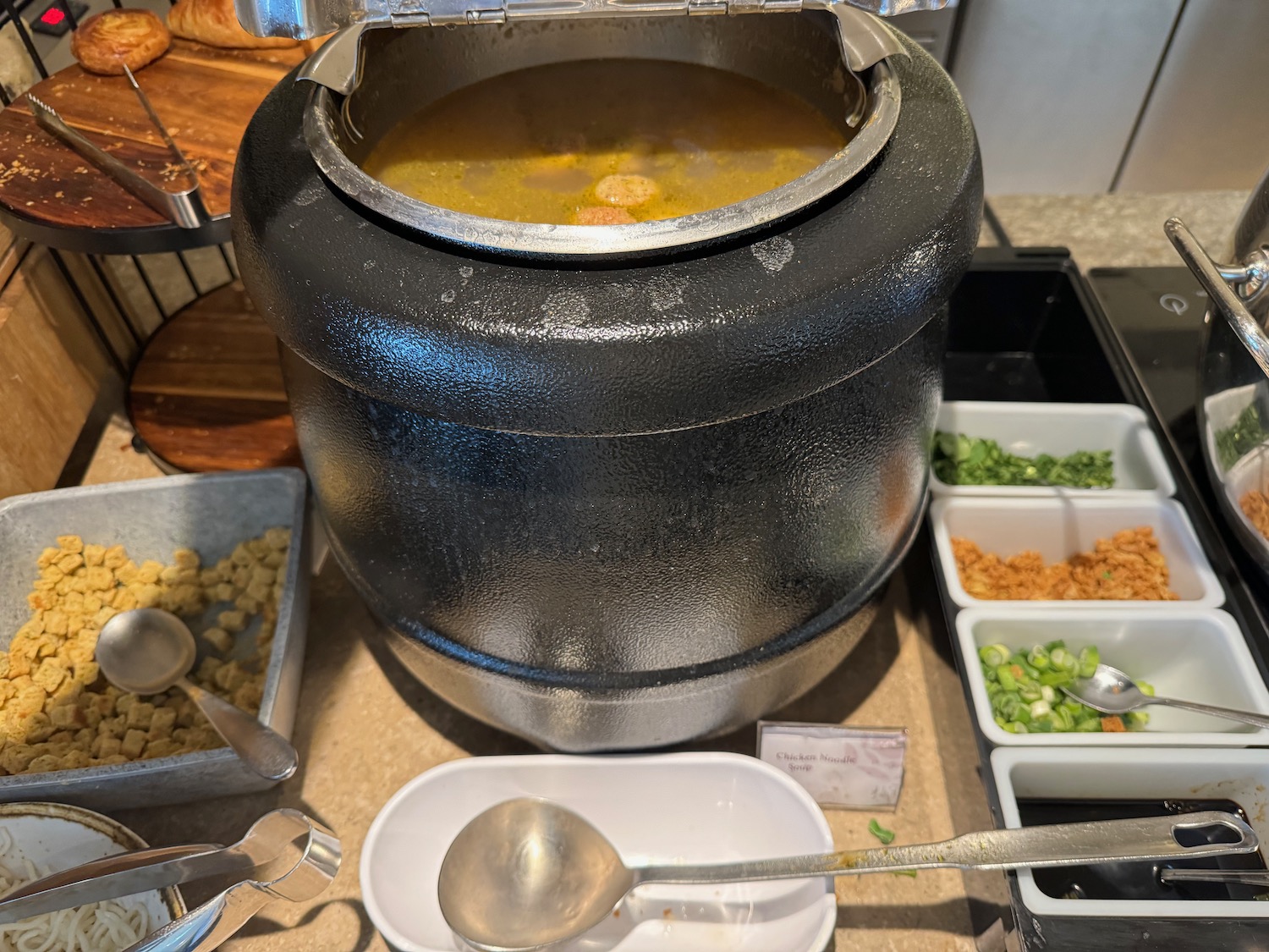 a large black pot with a lid open with a lid open and a metal lid with a lid open