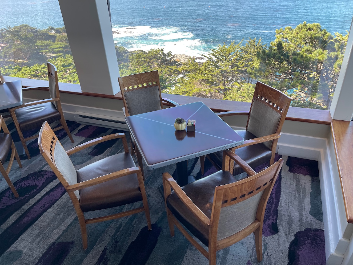 a table and chairs on a balcony overlooking the ocean