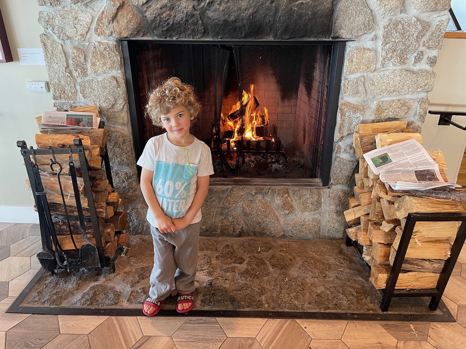 a child standing in front of a fireplace