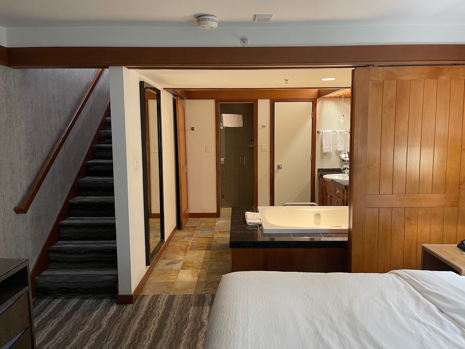 a bedroom with a bathtub and stairs