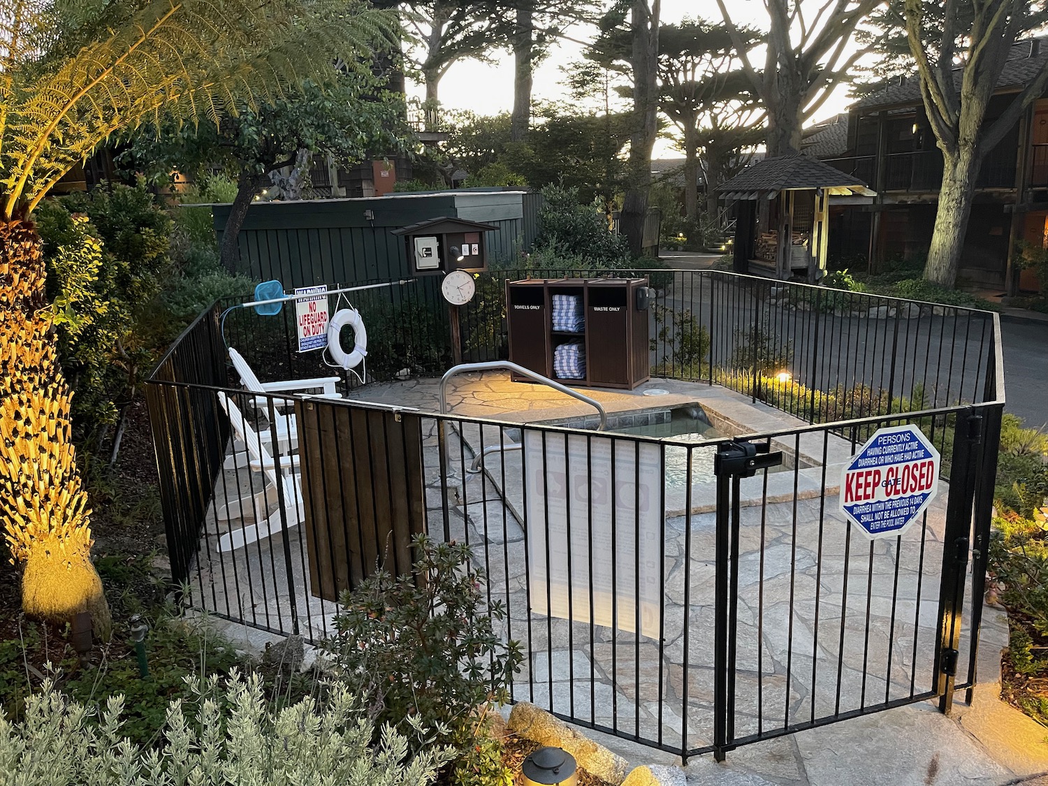 a fenced backyard with a pool and a hot tub