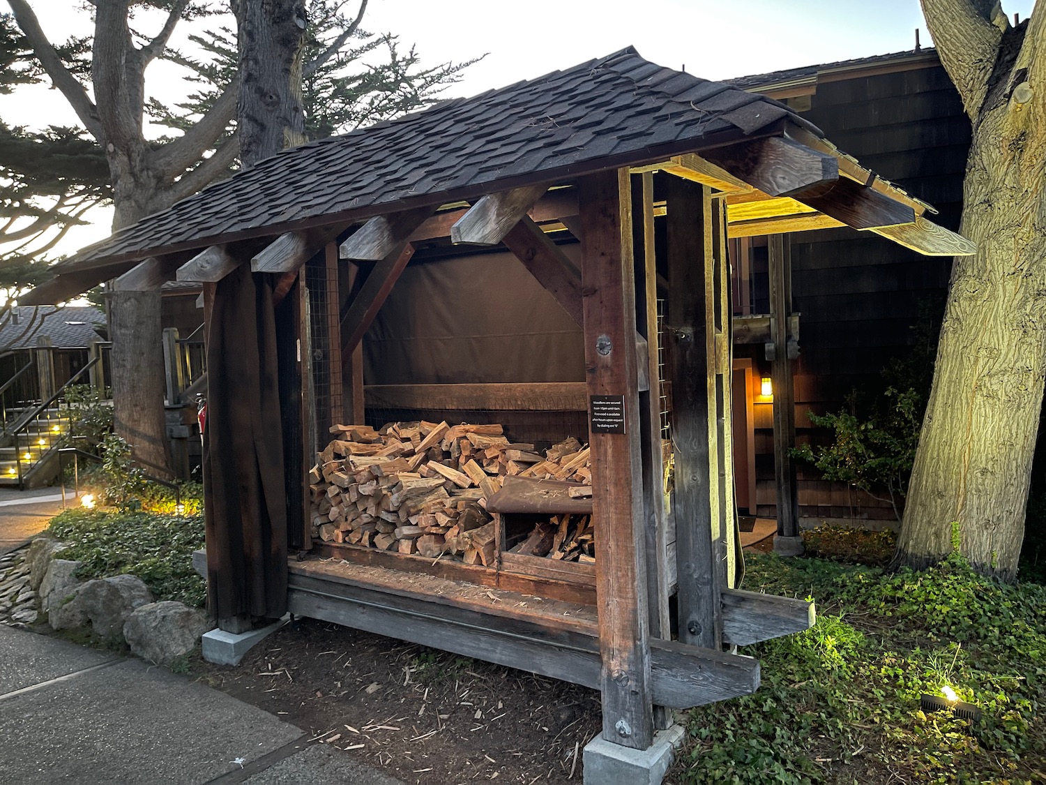 a wood shed with a pile of wood