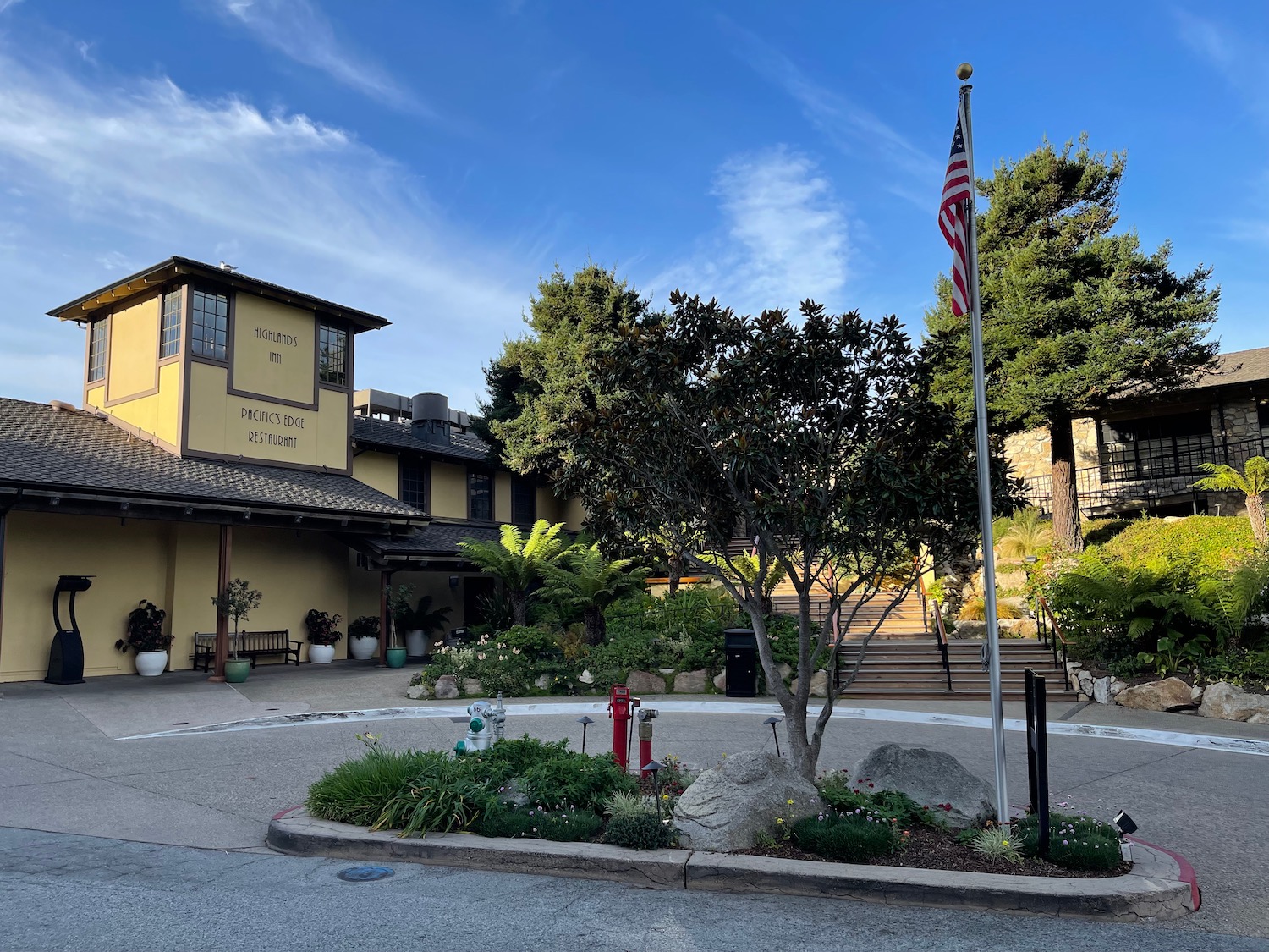 a building with a flag pole and a tree