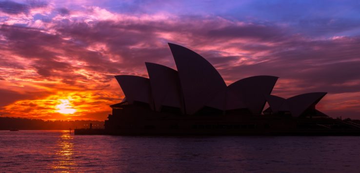 a building with a curved roof and a sunset