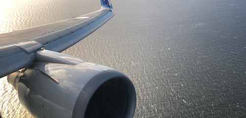 an airplane wing with water in the background