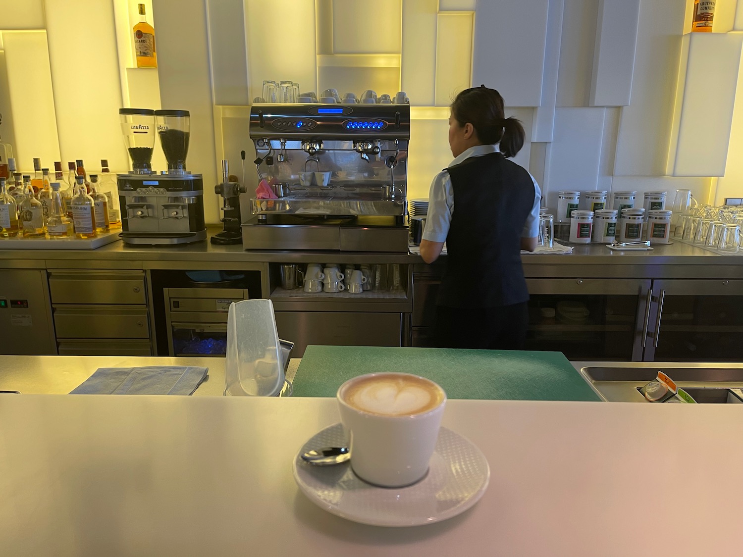 a woman standing behind a counter in a coffee shop