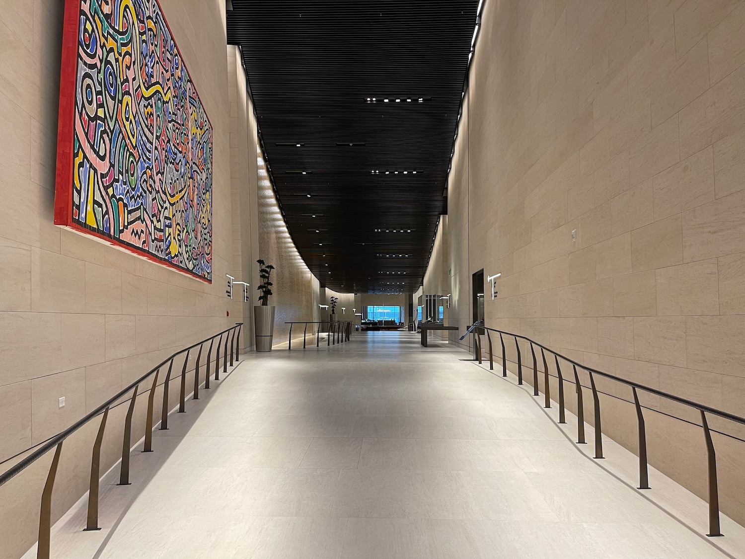 a long hallway with a large painting on the wall