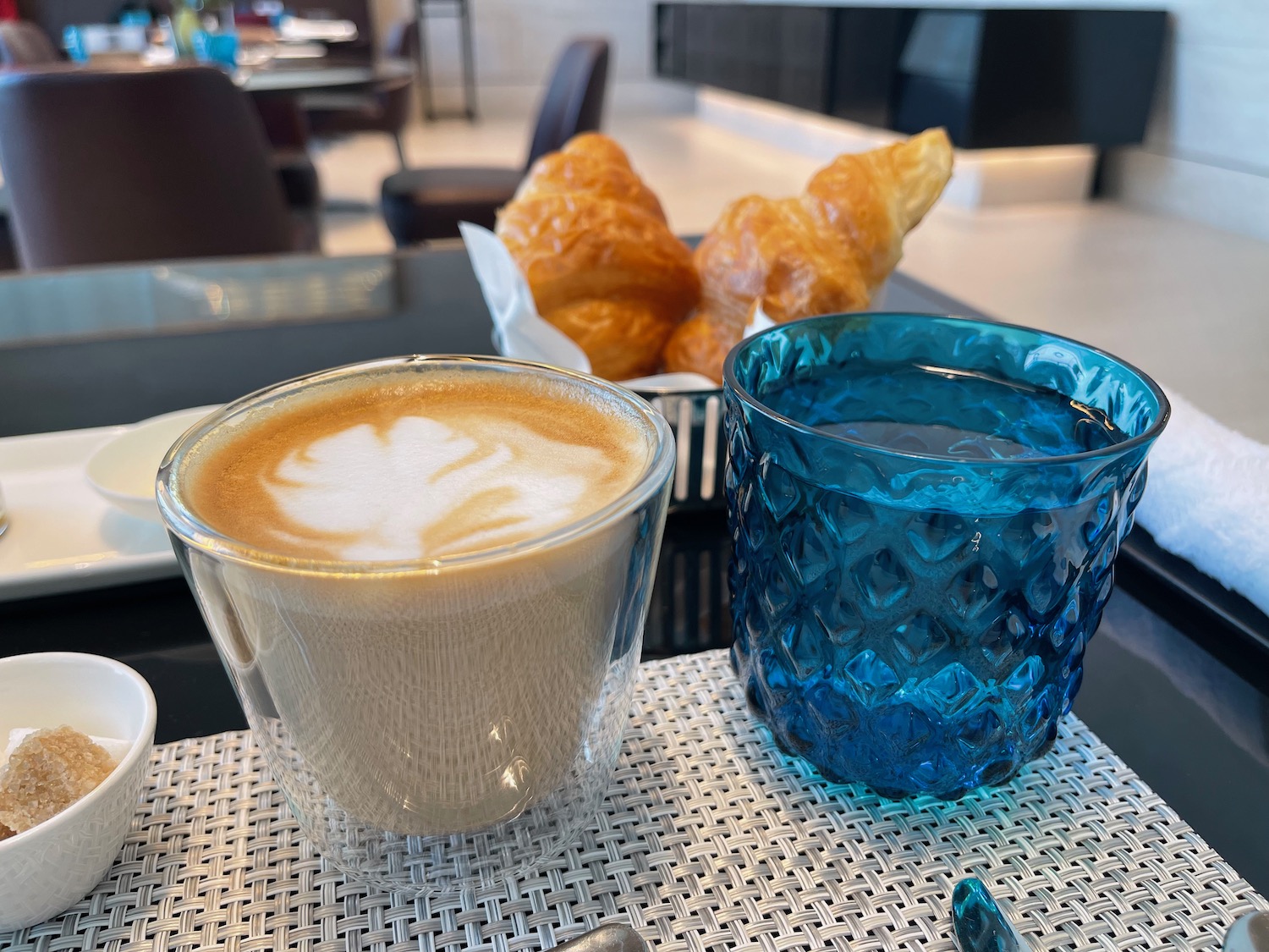 a cup of coffee and croissants on a table