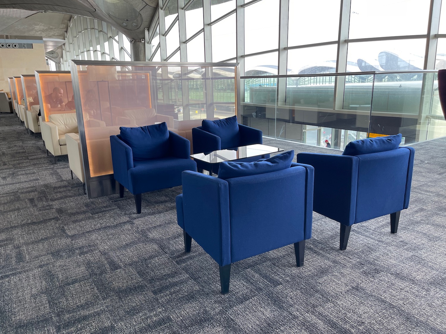a group of blue chairs in a room with a glass wall
