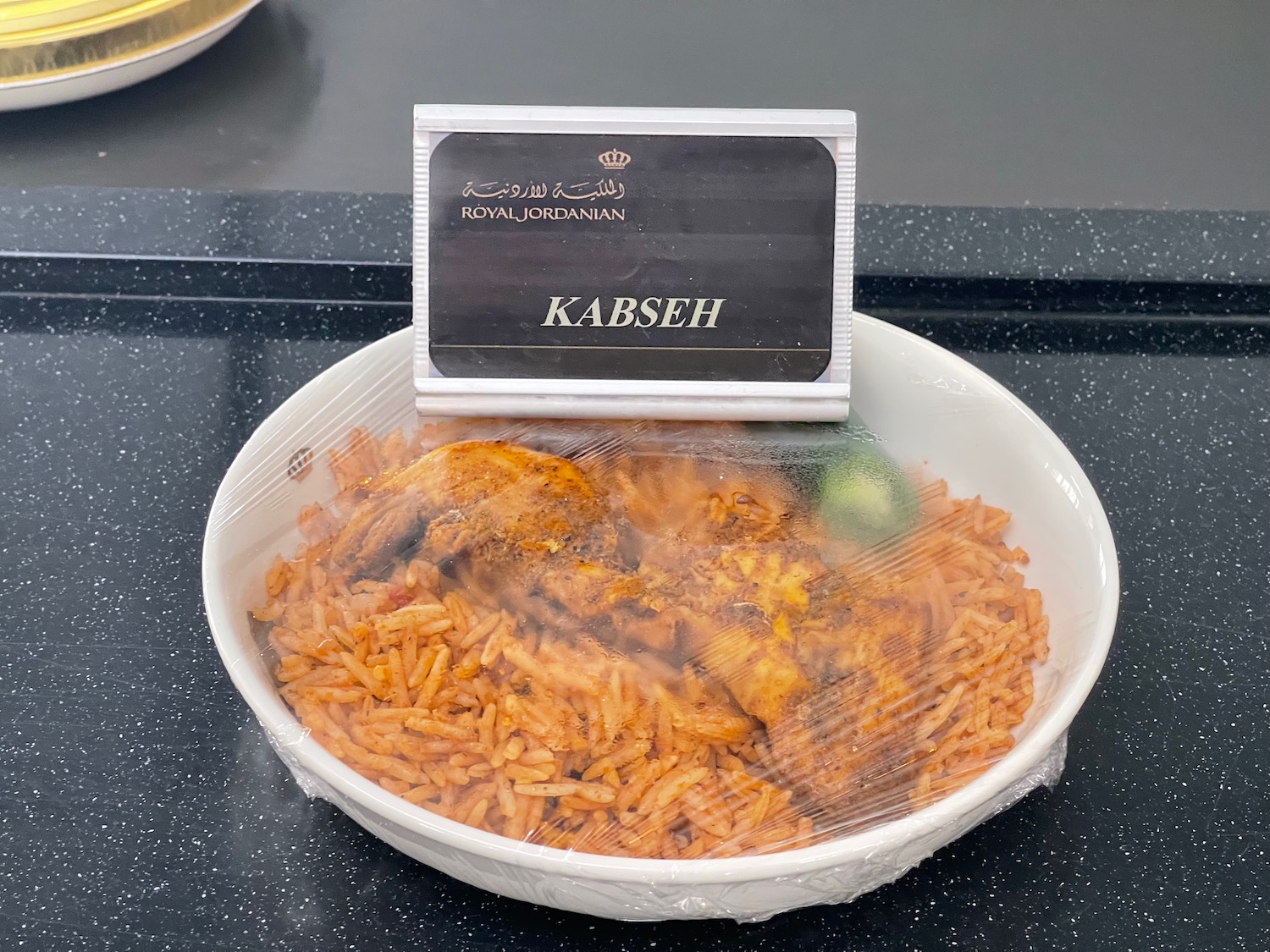 a bowl of rice and meat with a sign