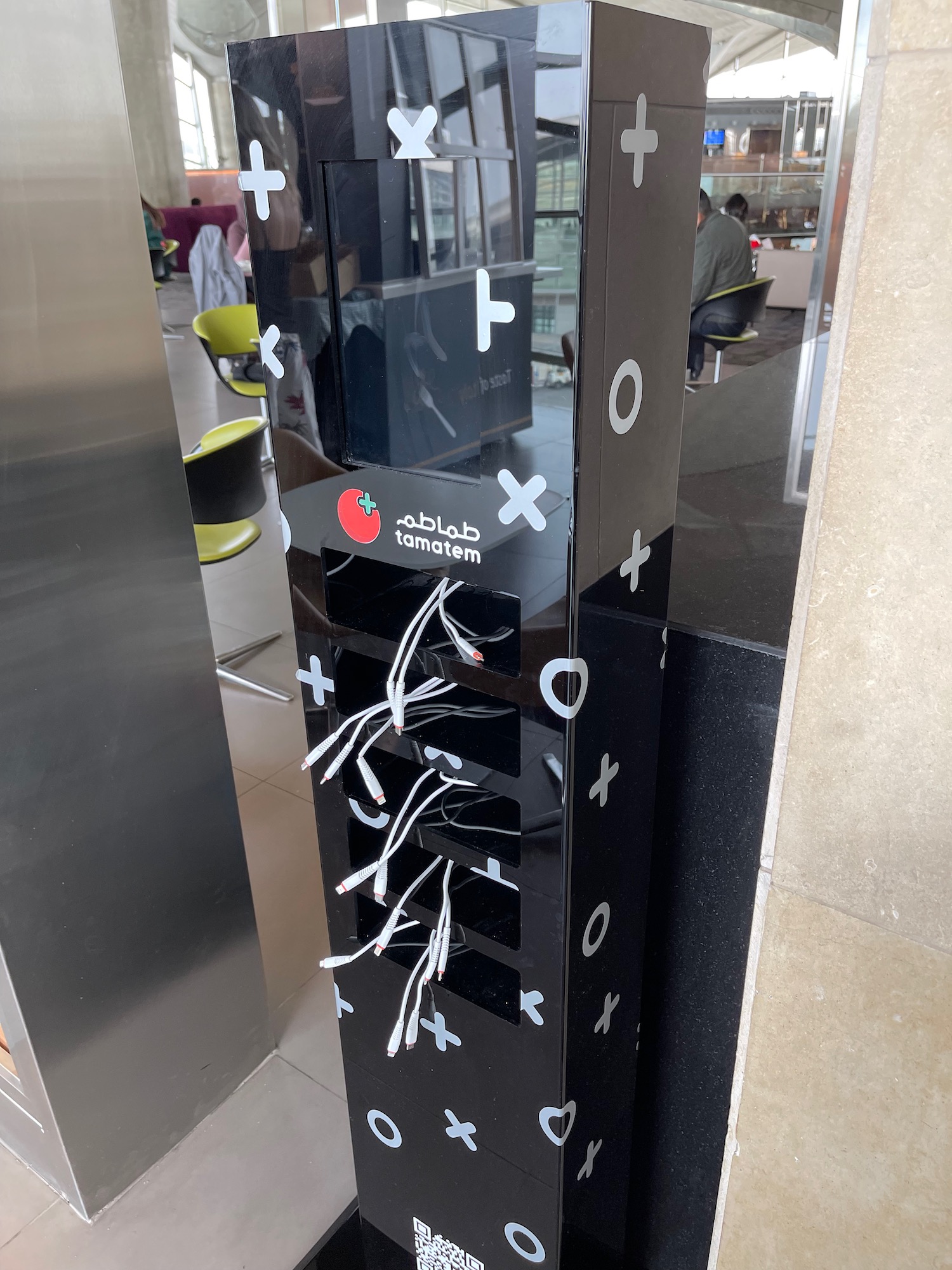 a black vending machine with white tags on it