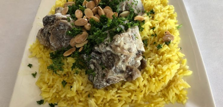 a plate of rice with meat and nuts