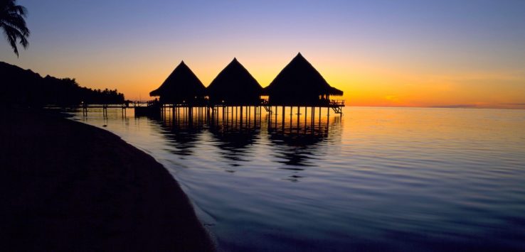a group of huts on stilts on water