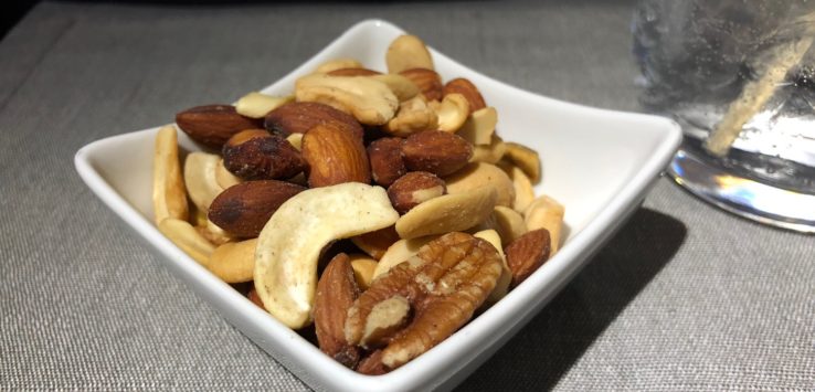 a bowl of mixed nuts and a glass of water