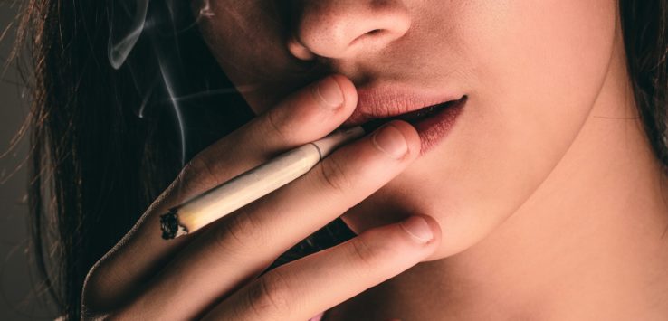 a close up of a woman smoking a cigarette