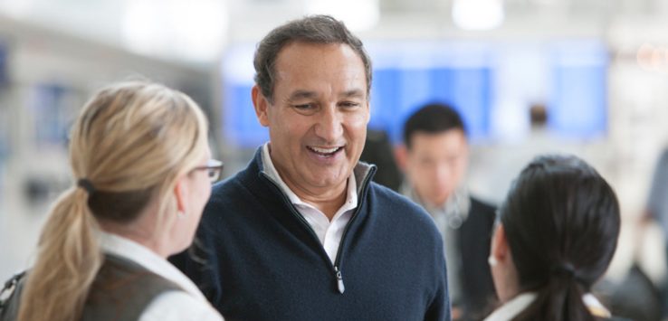 a man in a black sweater talking to a group of people