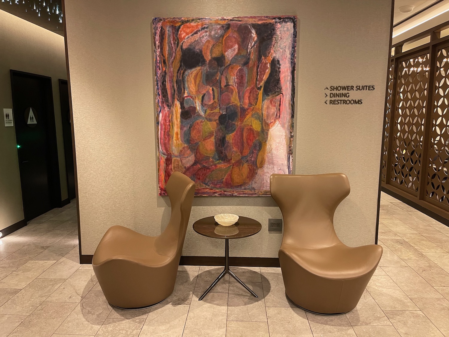 two chairs and a table in front of a painting