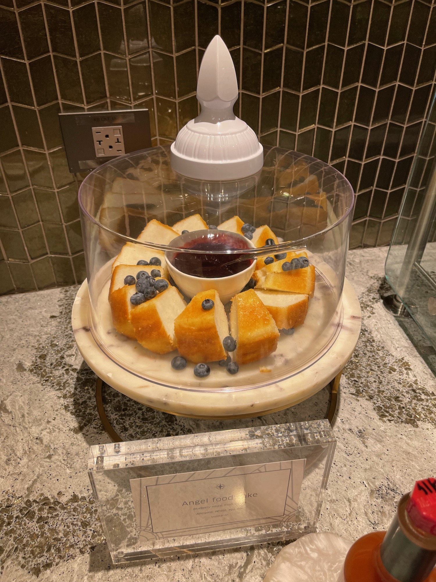 a plate of blueberries and bread with a glass dome