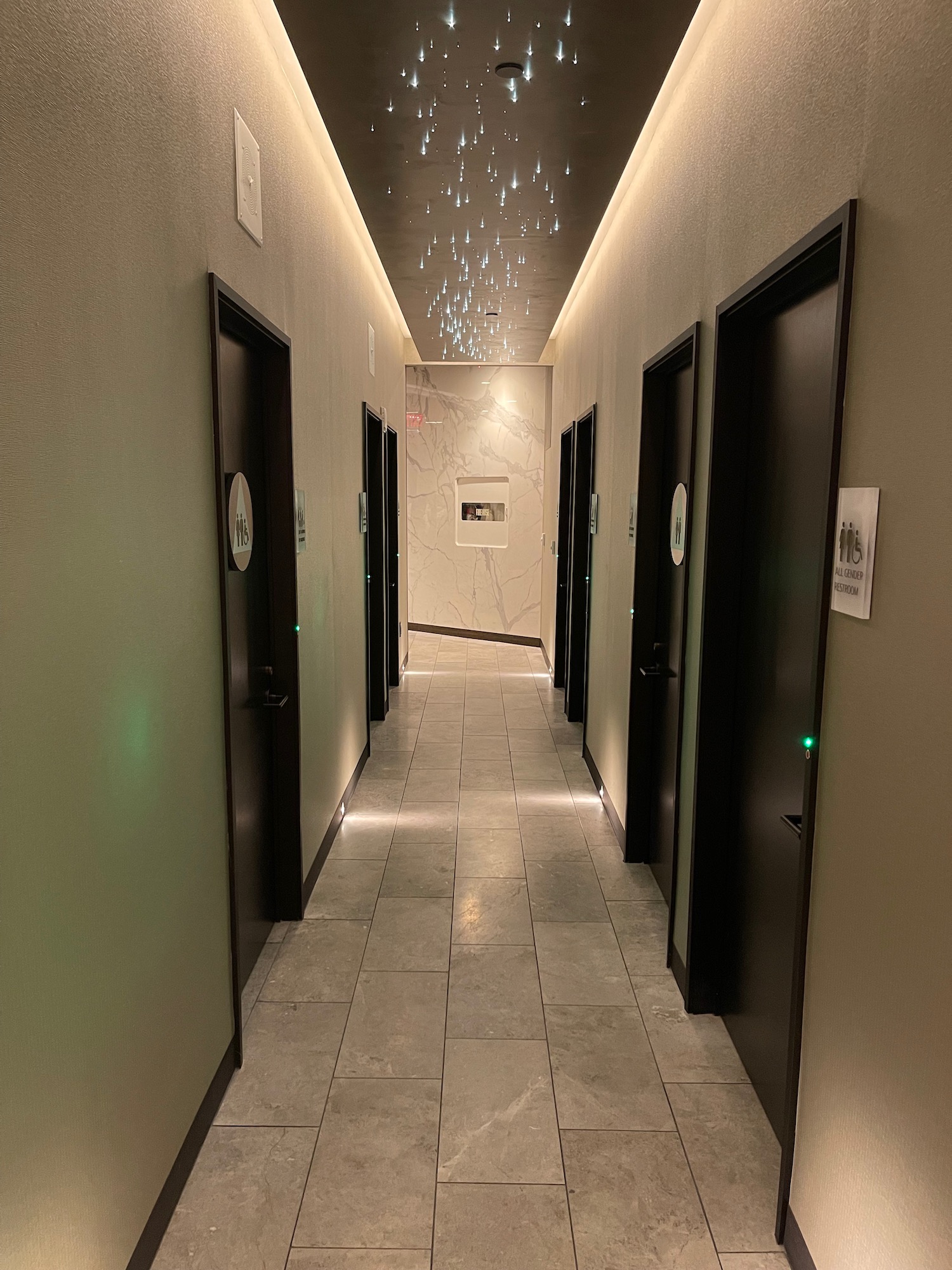 a hallway with black doors and lights