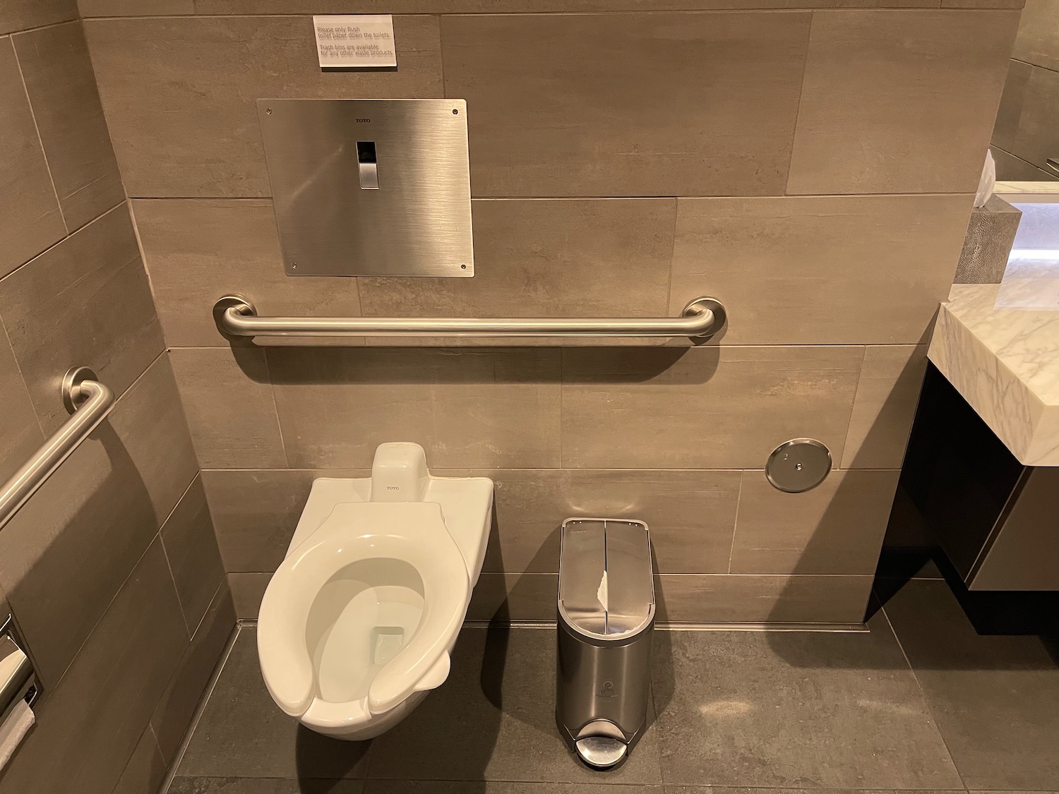 a toilet and trash can in a bathroom