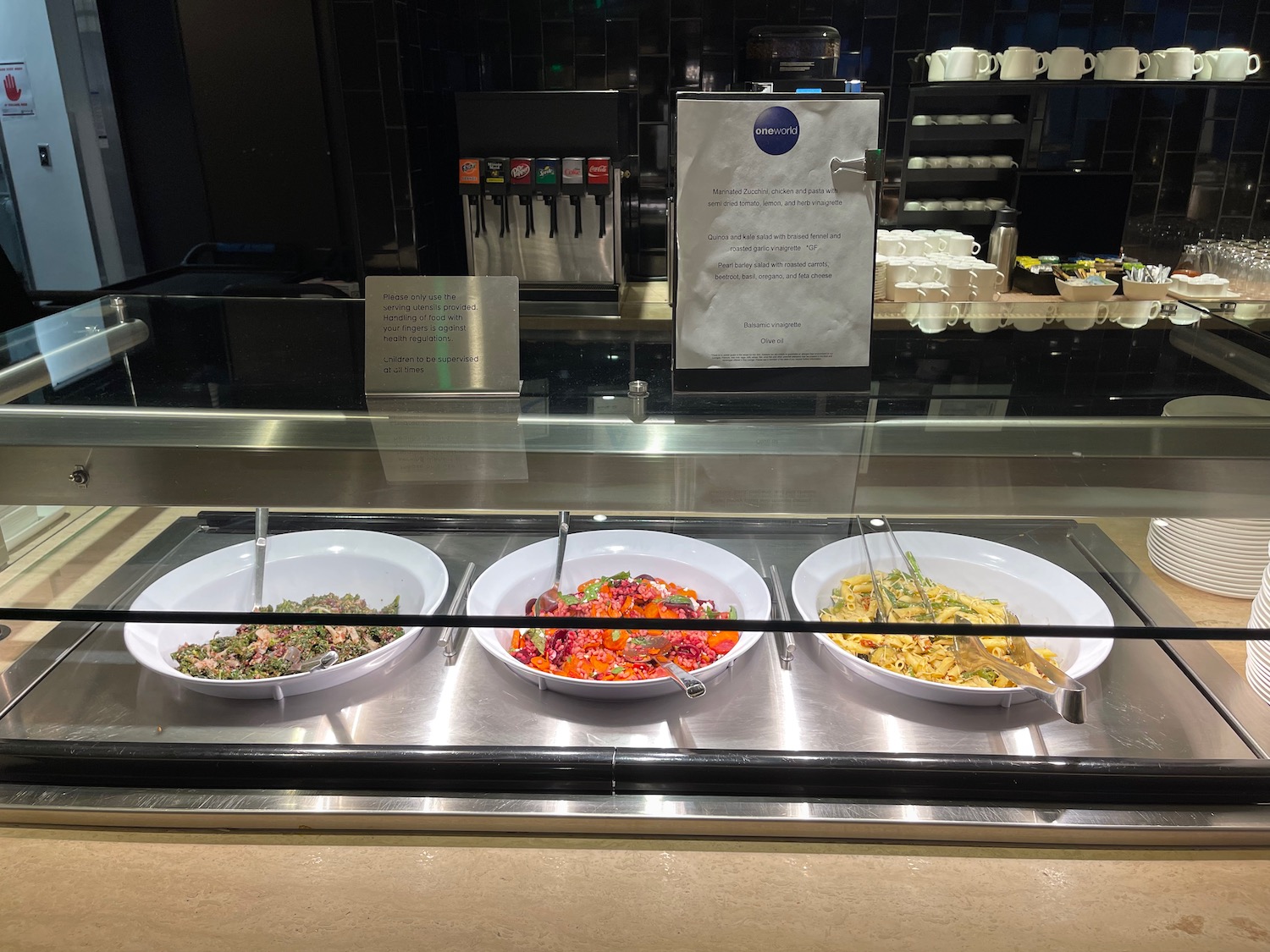 a row of bowls of food in a buffet